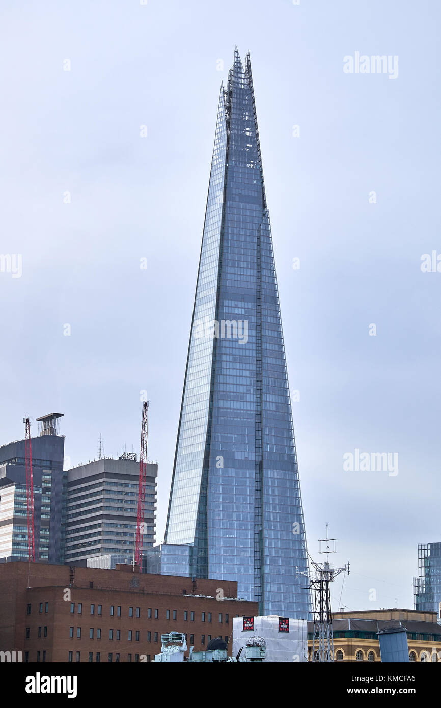 London City - Dezember 24, 2016: Die Spitzen Wolkenkratzer Shard zu einem grauen Himmel steigenden unter den niedrigeren Gebäuden Stockfoto