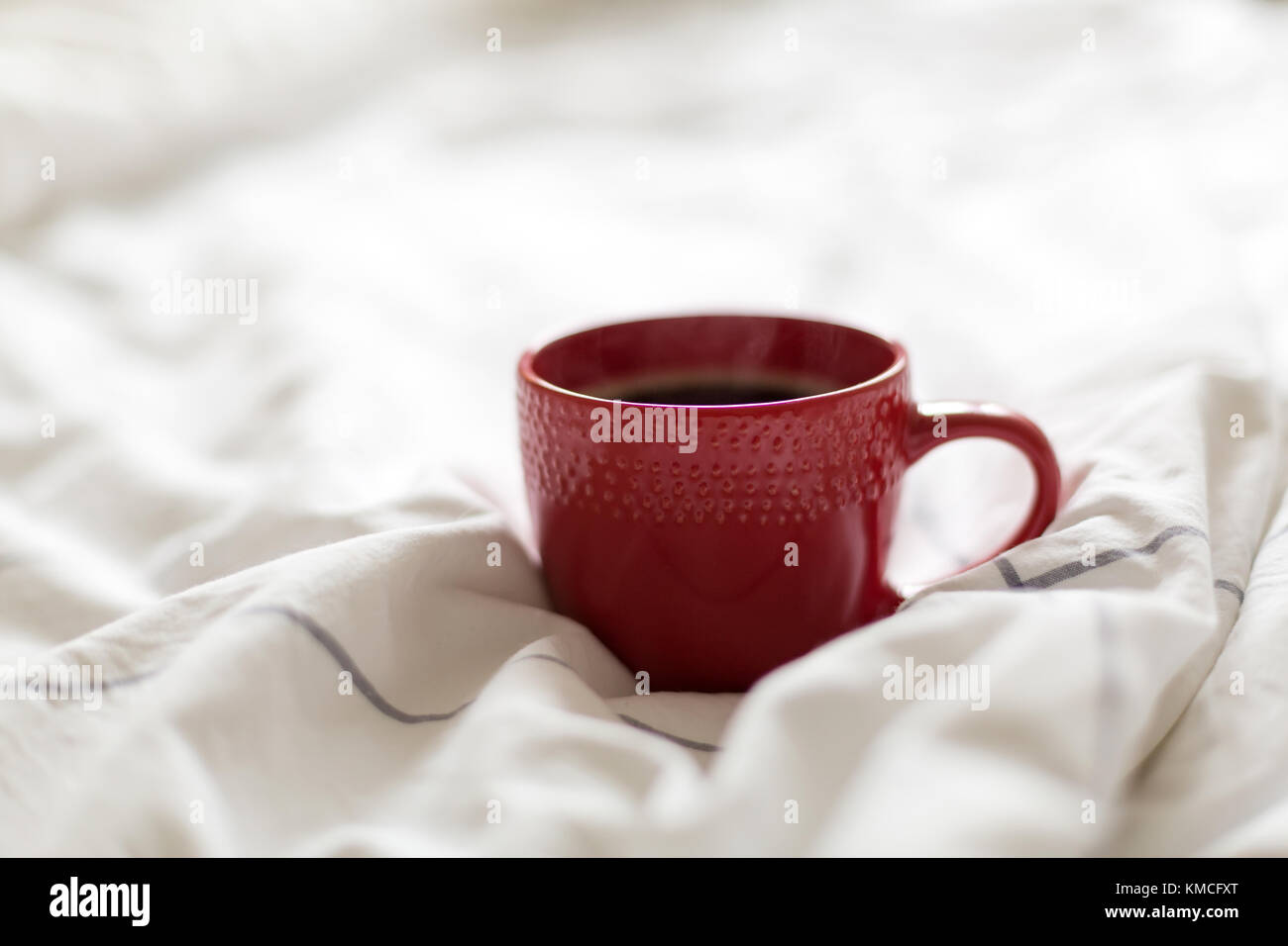 Kaffee in rot Schale serviert im Bett Stockfoto