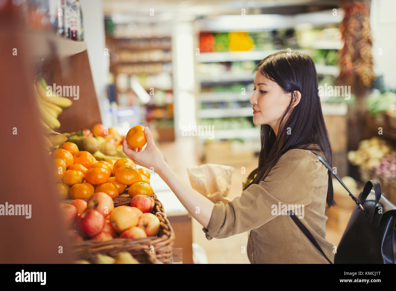Junge Frau einkaufen, Untersuchung Orangen im Lebensmittelgeschäft Stockfoto