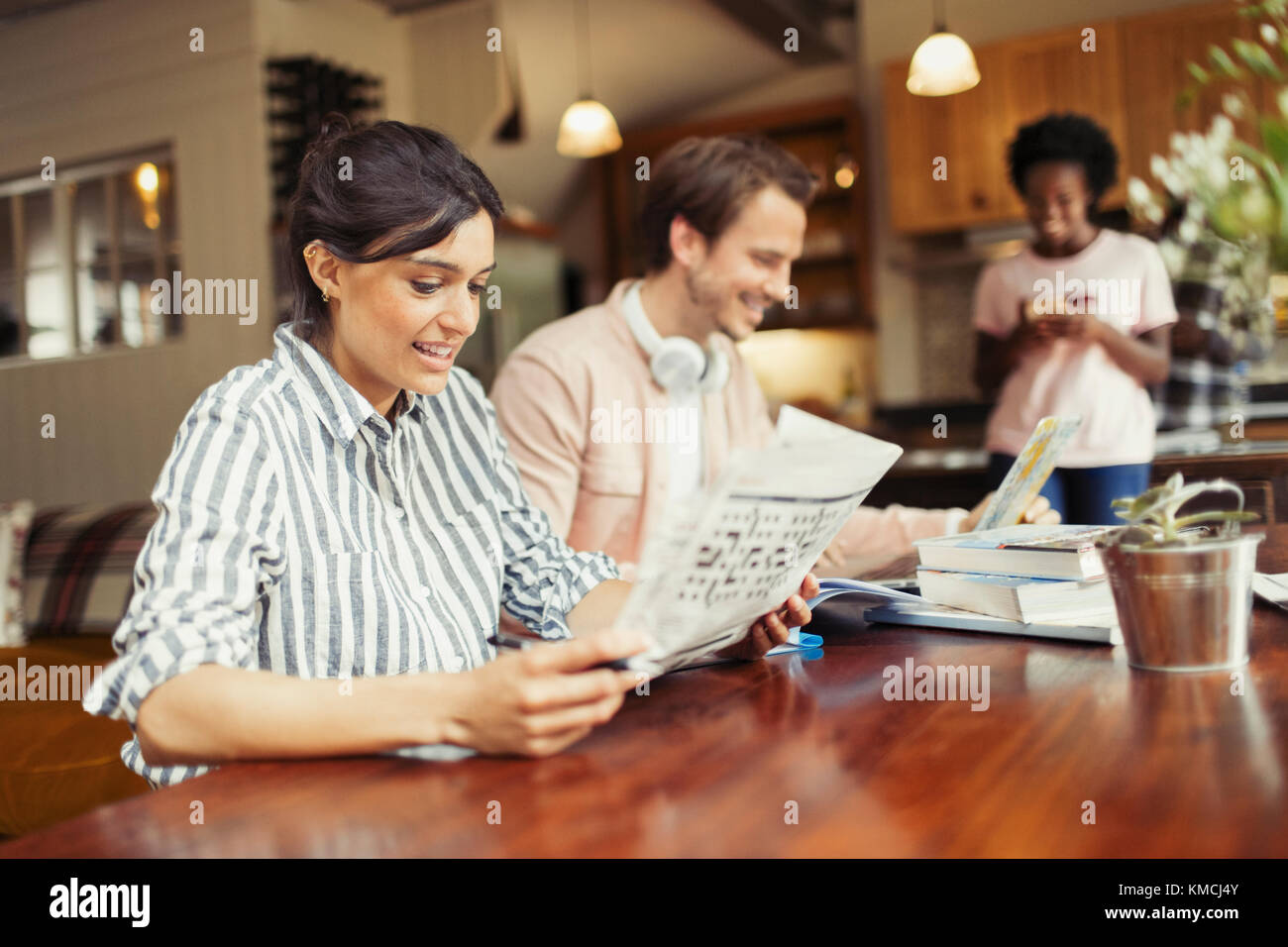 Frau liest Zeitung am Esstisch Stockfoto
