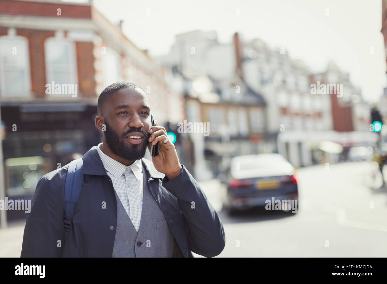 Geschäftsmann im Gespräch auf Handy auf sonnigen städtischen Straße Stockfoto