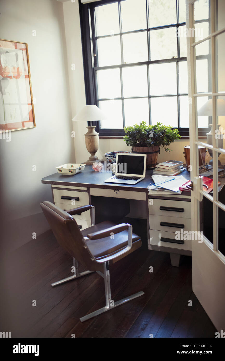Laptop und Schreibarbeit auf dem Schreibtisch im Heimbüro Stockfoto