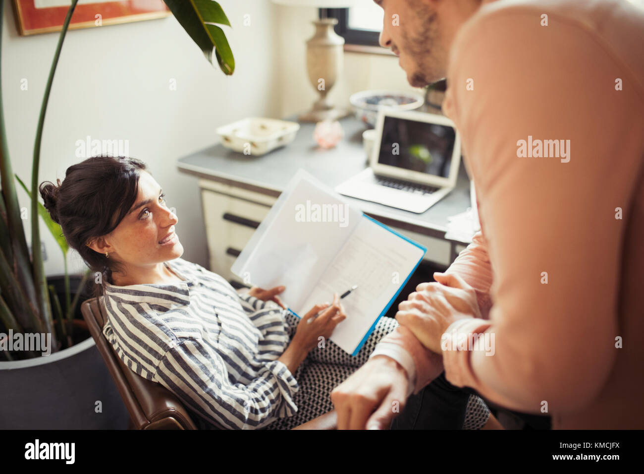 Geschäftsfrau Schreibarbeit diskutiert mit Kollege im Büro Stockfoto