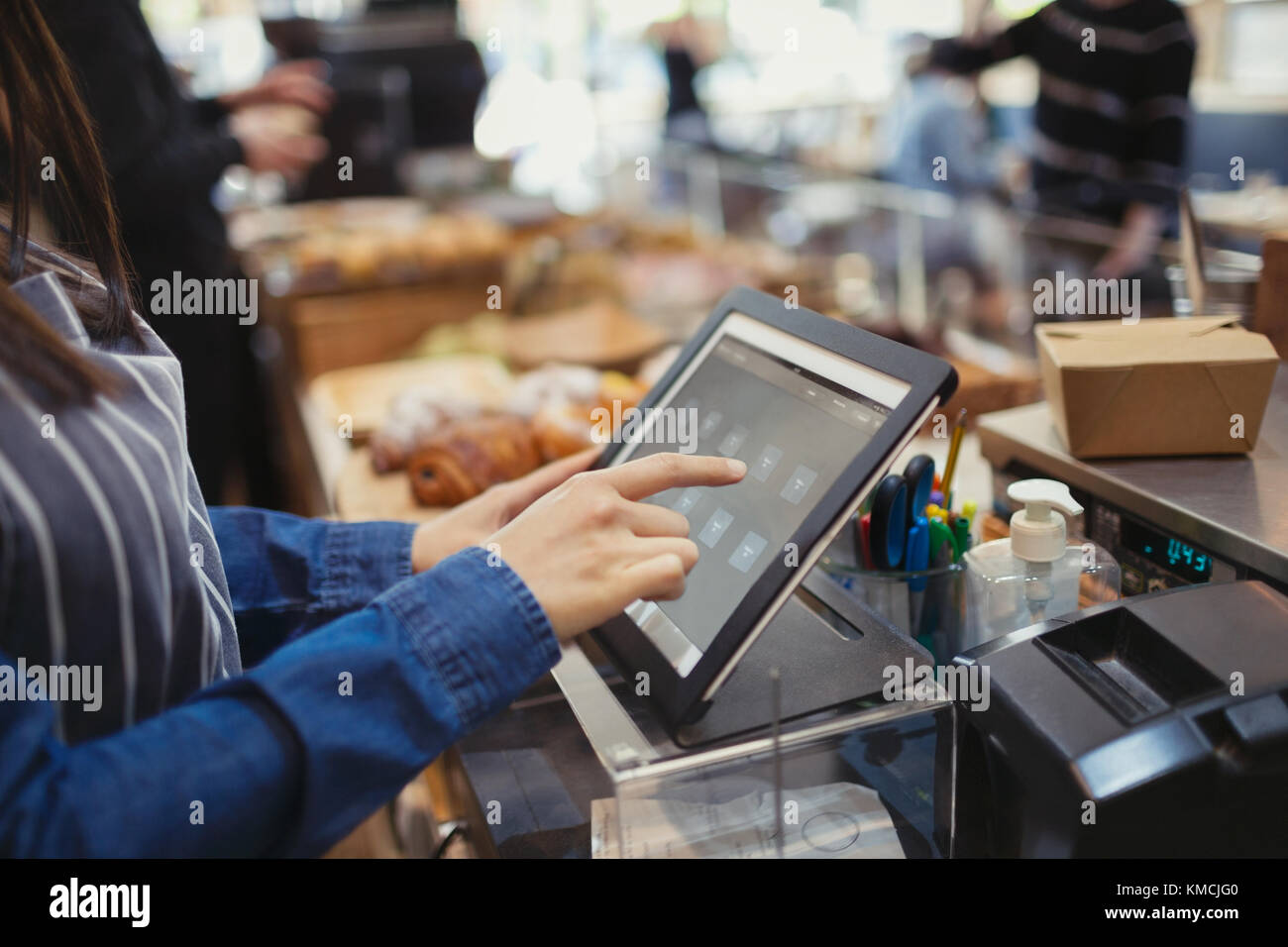 Kassierer mit Touchscreen-Kasse im Café Stockfoto