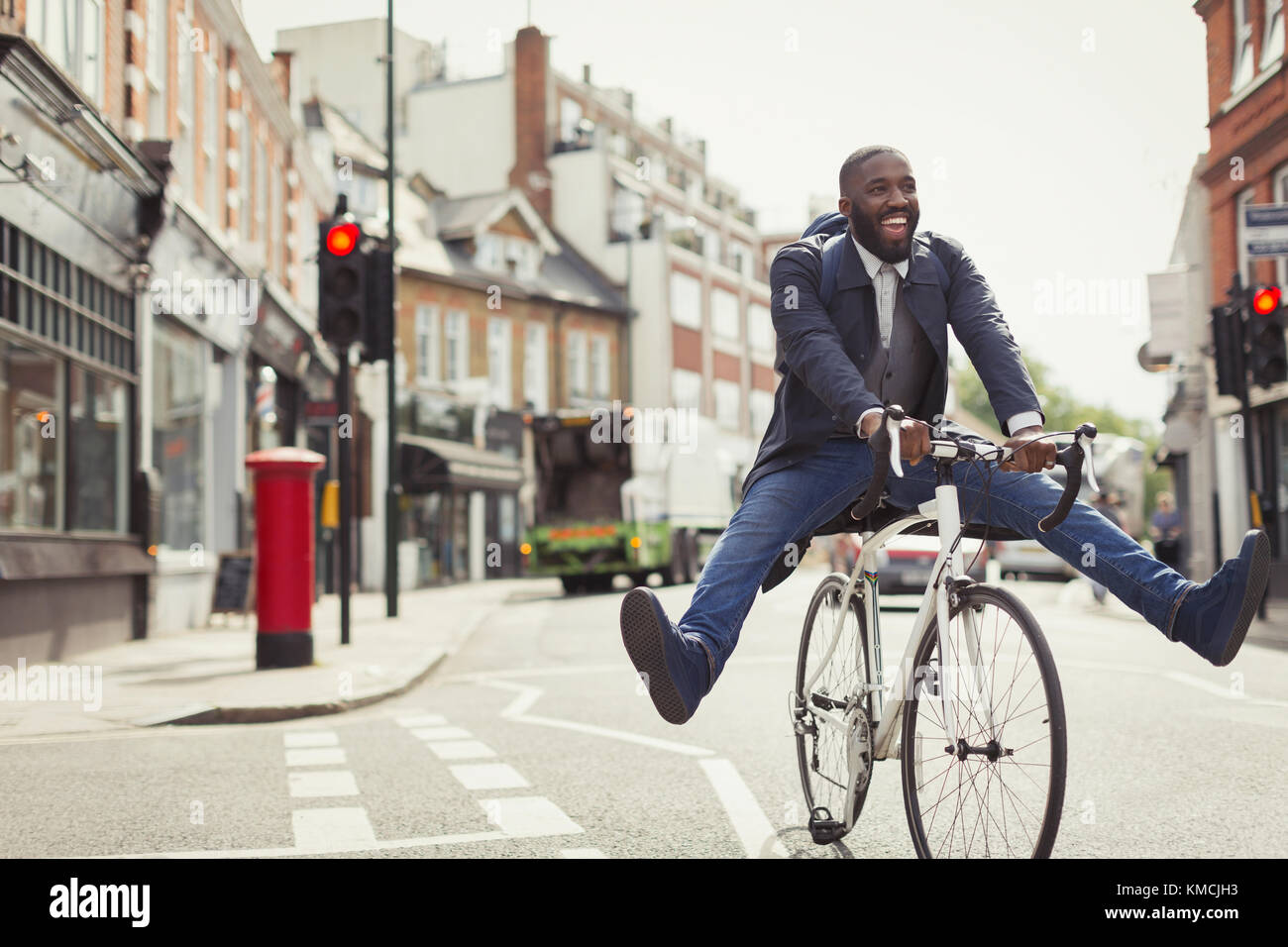Verspielt junge Geschäftsmann pendeln, Fahrrad fahren auf der städtischen Straße Stockfoto