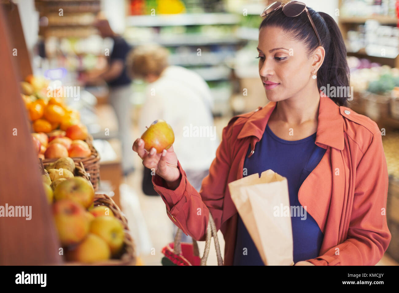 Frau einkaufen, untersuchen Apfel im Lebensmittelgeschäft Stockfoto