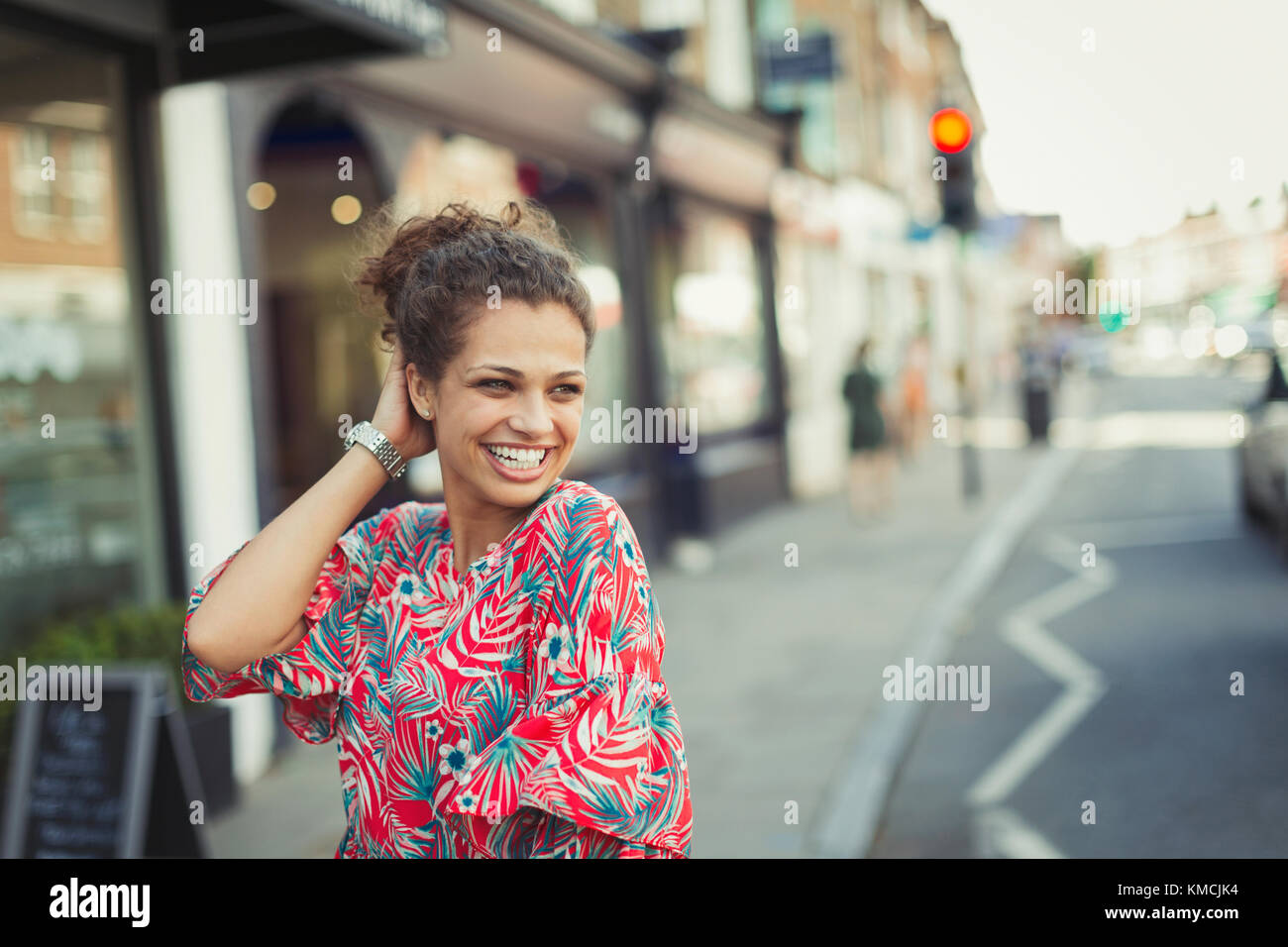 Porträt selbstbewusste, lachende junge Frau auf der städtischen Straße Stockfoto