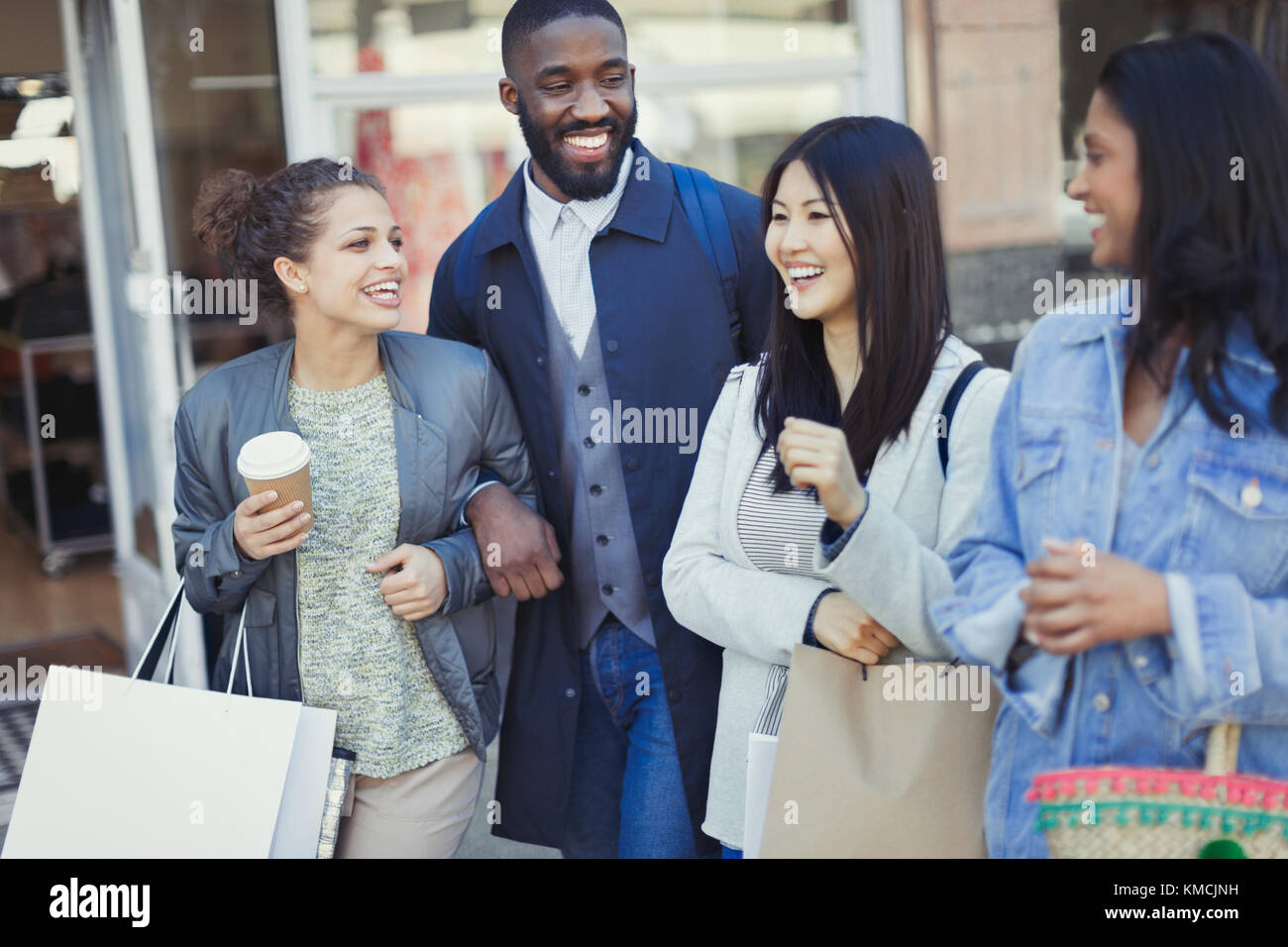 Lächelnde Freunde mit Kaffee und Einkaufstaschen Stockfoto