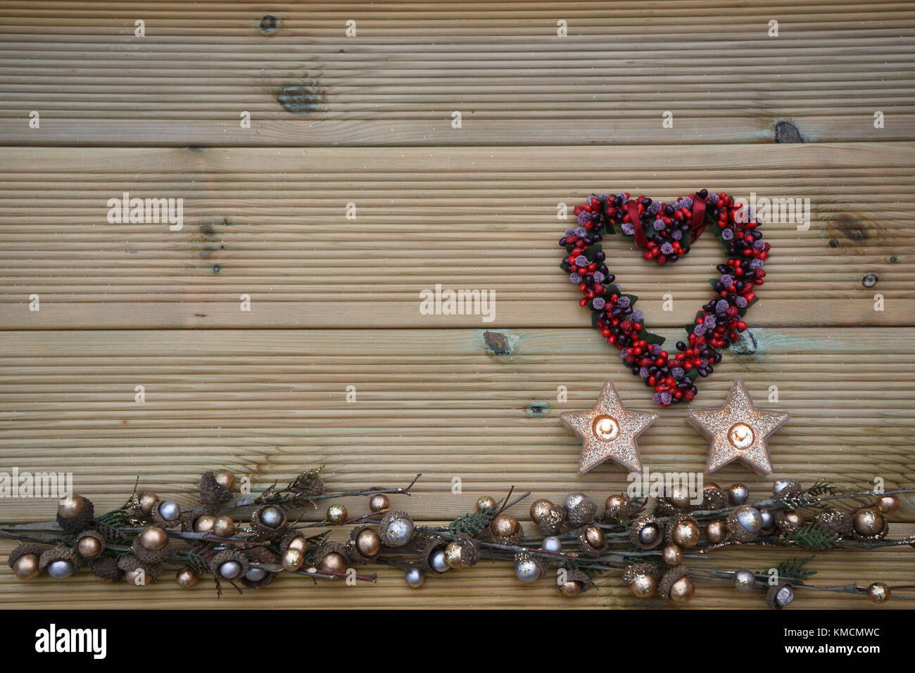 Romantische Weihnachtszeit fotografie Bild mit Deko Obst Beeren in Liebe Herz Form mit Kerzenlicht und rustikalem Holz Kopie Raum Hintergrund Stockfoto