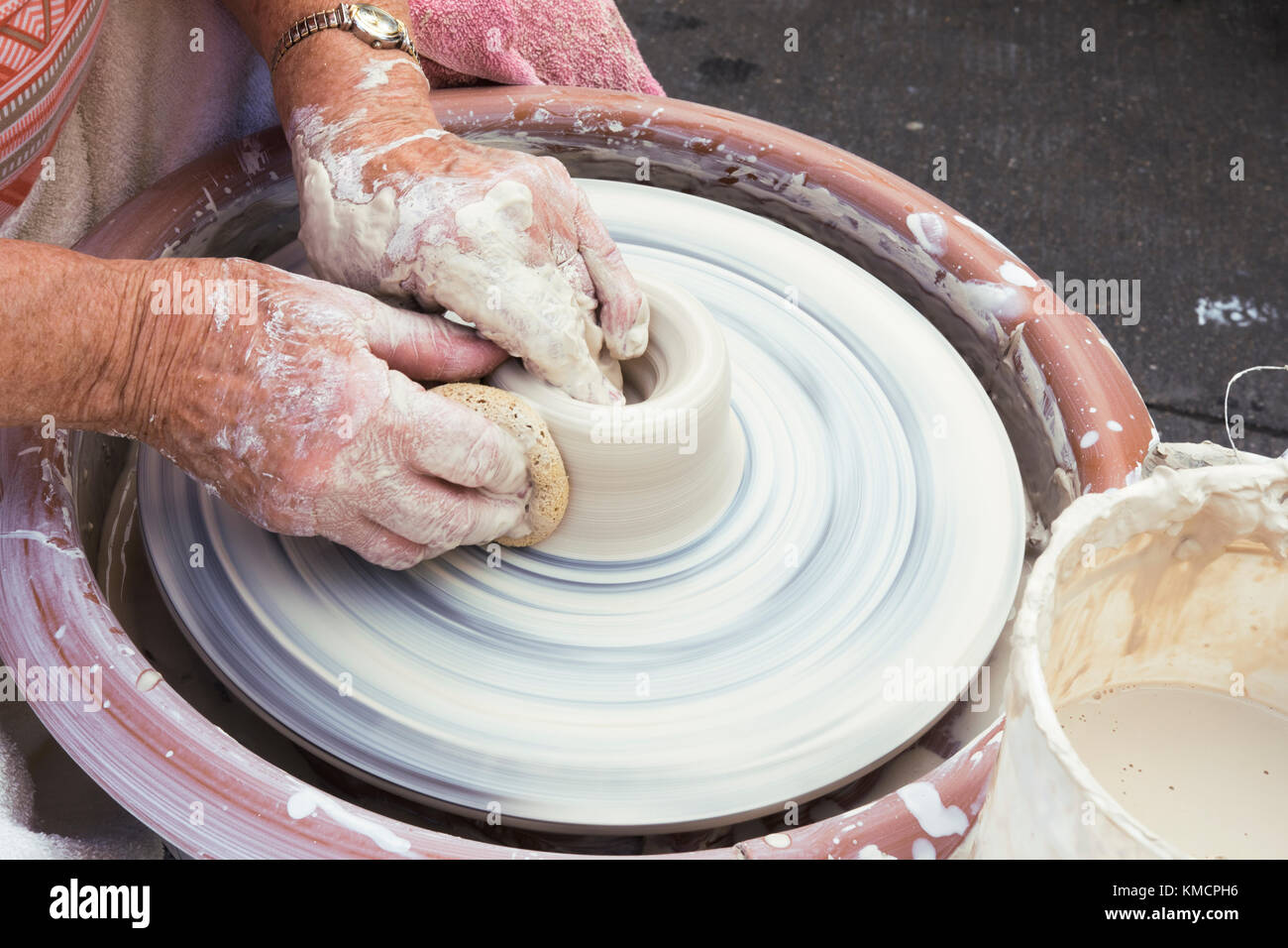 Hände von einer älteren Frau werfen Tonwaren auf Keramik Rad Stockfoto