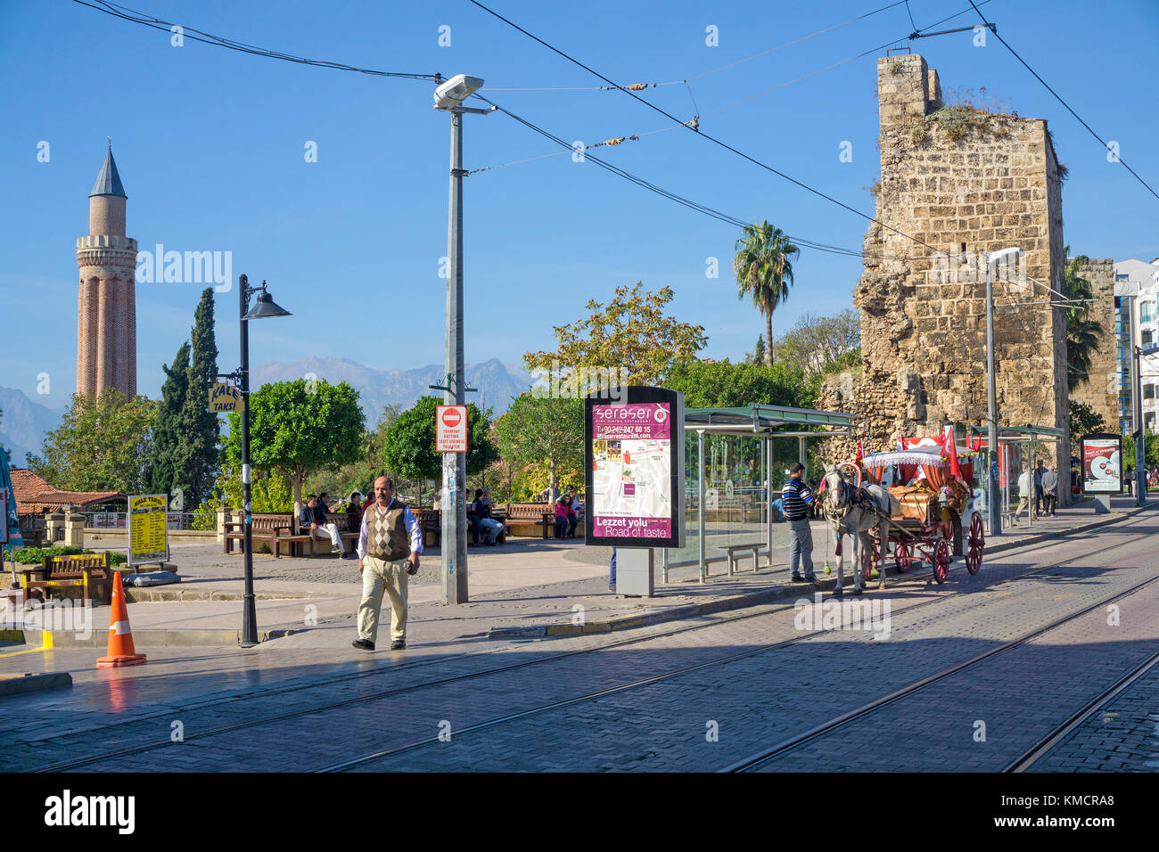 Dekoriert mit der Kutsche an der Straßenbahnhaltestelle warten, links das Yivli Minarett, Kaleici, der Altstadt von Antalya, Türkische Riviera, Türkei Stockfoto
