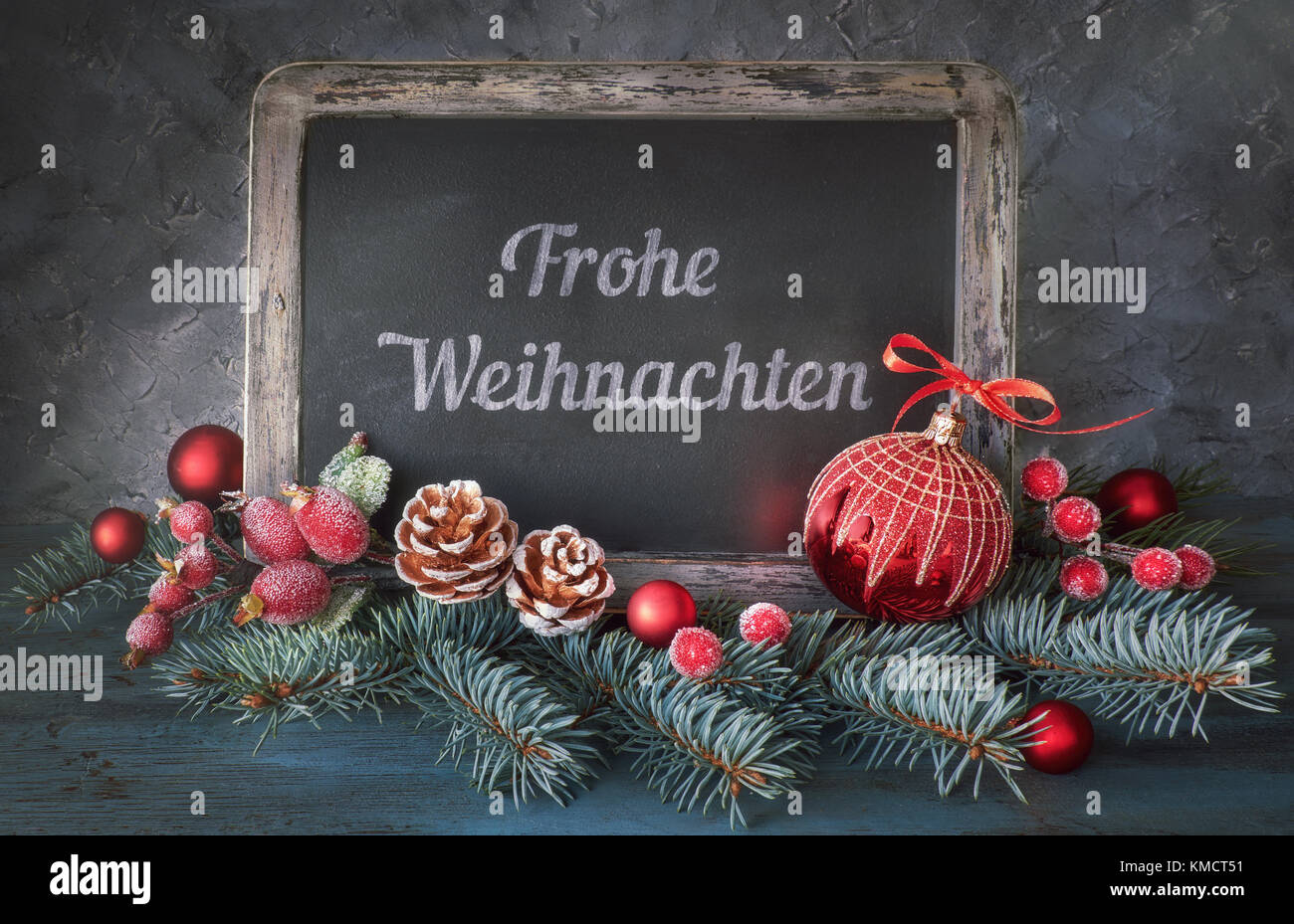 Tafel mit Gruß Text "Frohe Weihachten" oder "Frohe Weihnachten!" in  Englisch, mit Weihnachtsschmuck auf dunklen rustikalen Hintergrund. Dieses  Bild ist Stockfotografie - Alamy