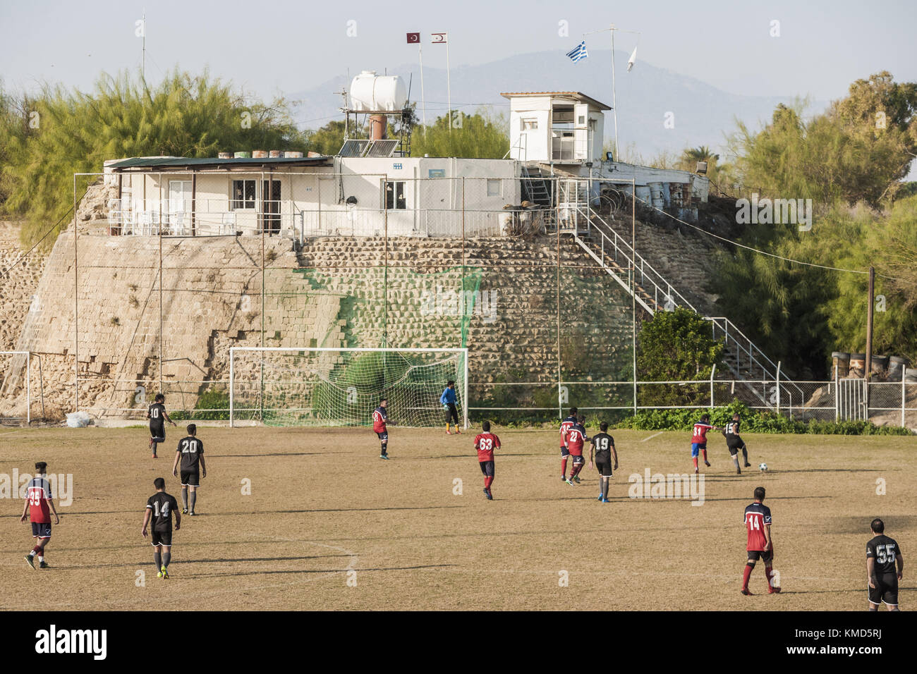 Fußballspiel zyprischer Teams unter einem Militärüberwachungsposten in der Pufferzone, die die türkische und die zyprische Seite der Stadt Nikosia trennt. Nach der Besetzung Zyperns durch türkische Truppen im Jahr 1974 wurde Nikosia in zwei Zonen getrennt, wobei die Türkei die Nordseite und Zypern die Südseite kontrollierte. Dezember 2017. Quelle: Celestino Arce/ZUMA Wire/Alamy Live News Stockfoto