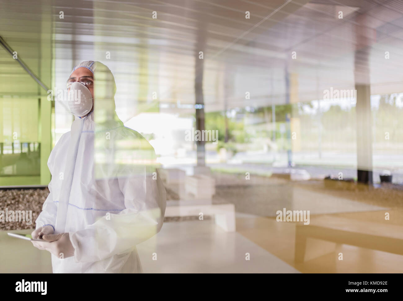 Wissenschaftler in Reinanzug mit digitalen Tablet am Fenster Stockfoto