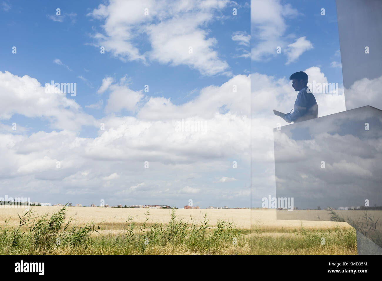 Silhouette Geschäftsmann schreiben auf einem modernen Balkon mit Blick auf sonnigen blauen Himmel Und Wolken Stockfoto