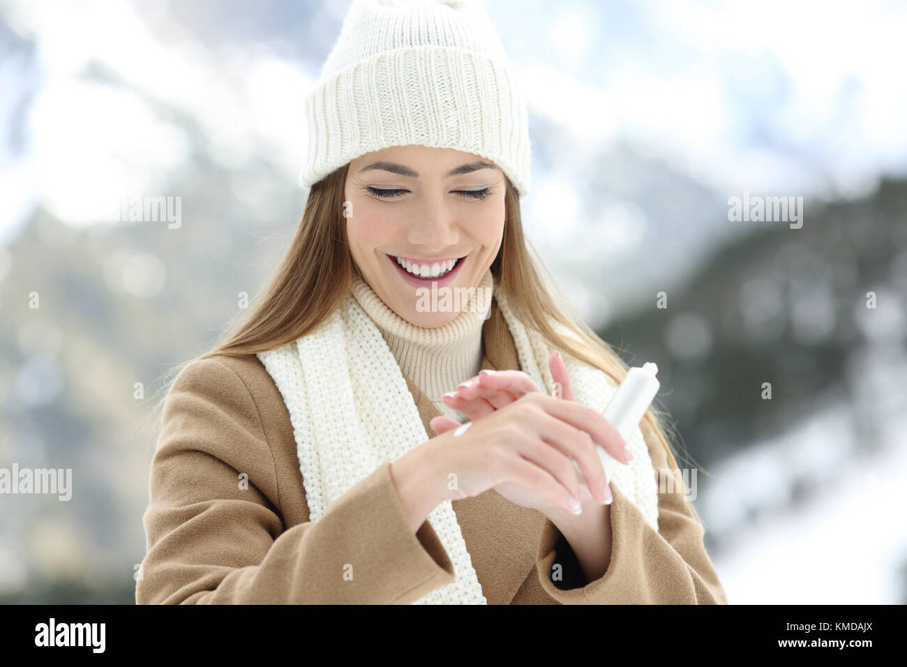 Vorderansicht Porträt einer Frau Anwendung Feuchtigkeits-creme Hände mit einem schneebedeckten Berge im Hintergrund zu hydratisieren Stockfoto