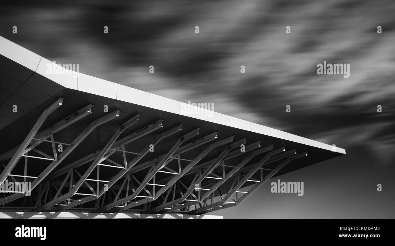 Monochromes Bild der architektonischen Details moderner Gebäude. Fotos mit langer Belichtungszeit mit ziehenden Wolken. Stockfoto