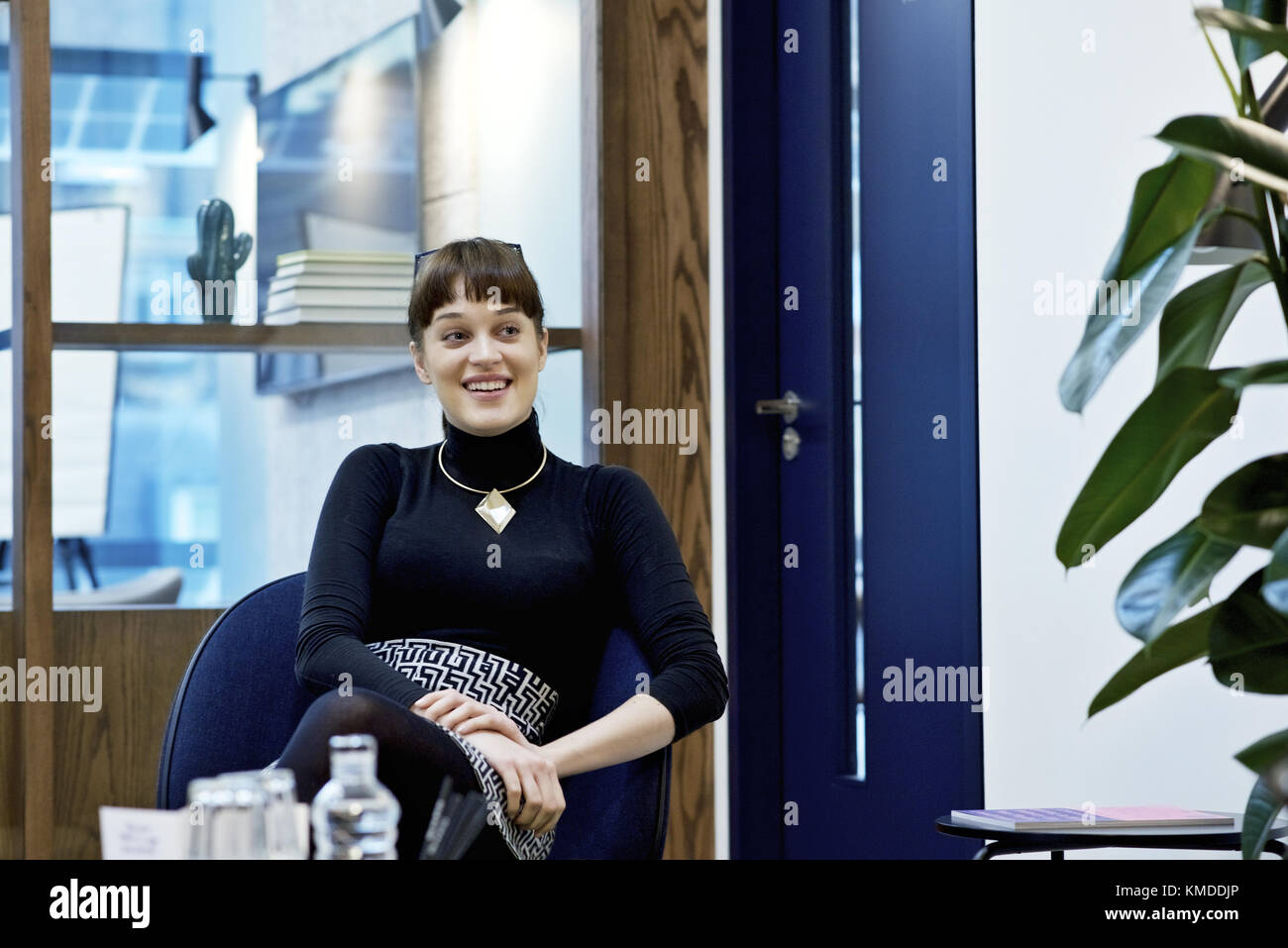 Kaukasische Geschäftsfrau lächelnd und deutete an Kollegen vor der Kamera, in einem modernen Büro Stockfoto