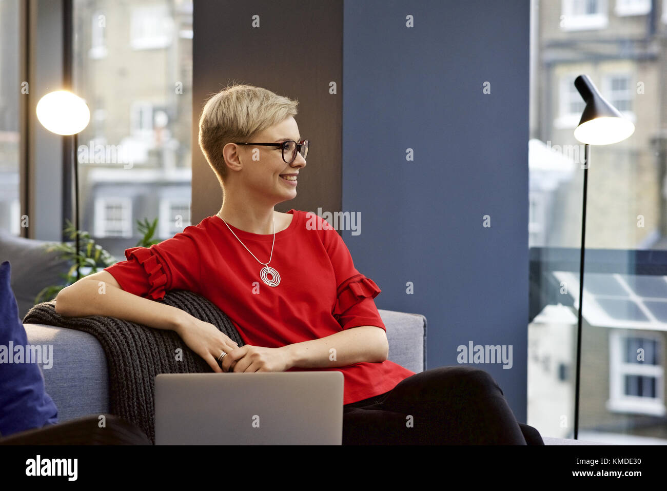 Kaukasische Geschäftsfrau in einem Büro mit einem Laptop in ein Gespräch und lächelnd an einen Kollegen vor der Kamera Stockfoto