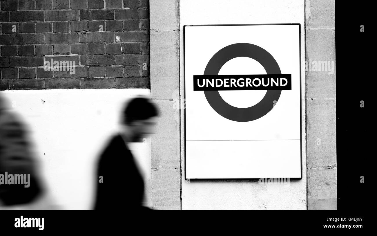 Pendler pass ein Londoner U-Schild an einem geschäftigen Tag, London, UK, September 2013 Stockfoto