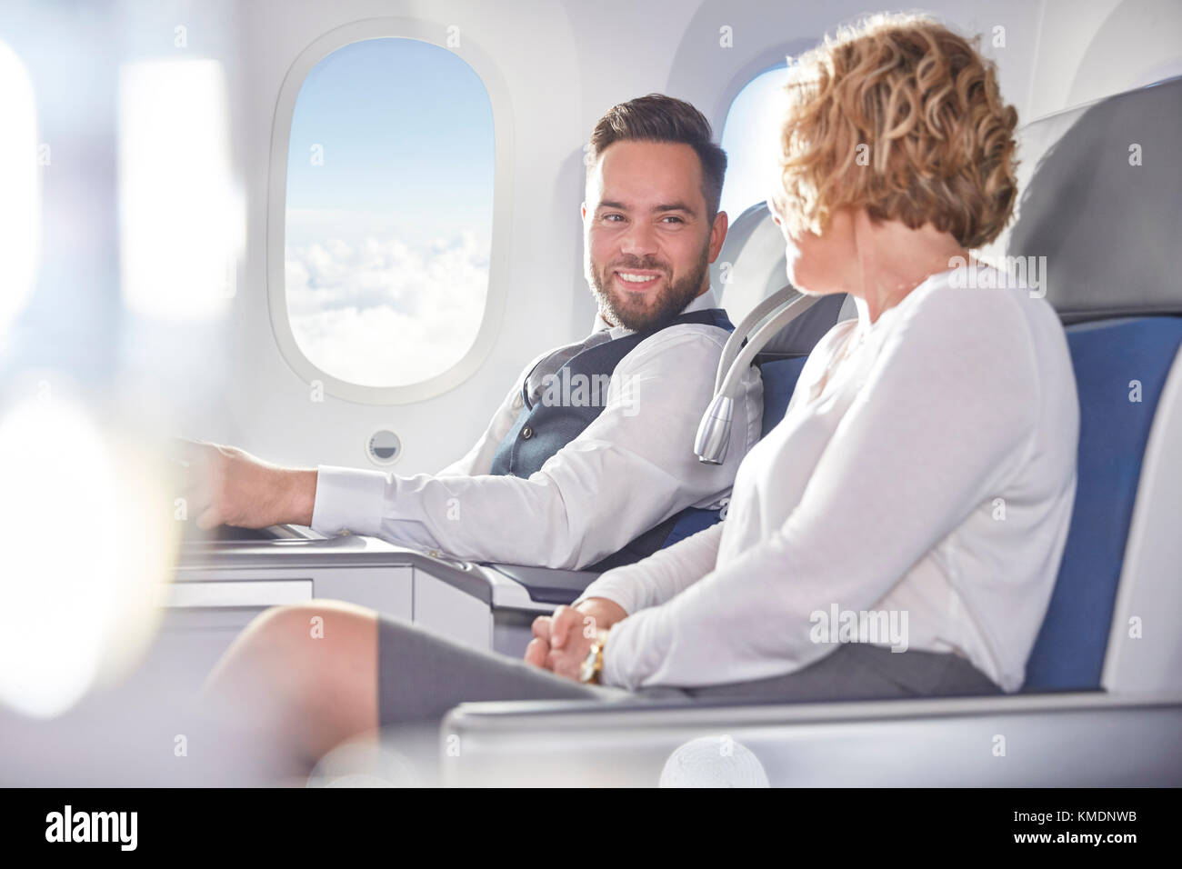 Lächelnder Geschäftsmann und Geschäftsfrau im Flugzeug Stockfoto