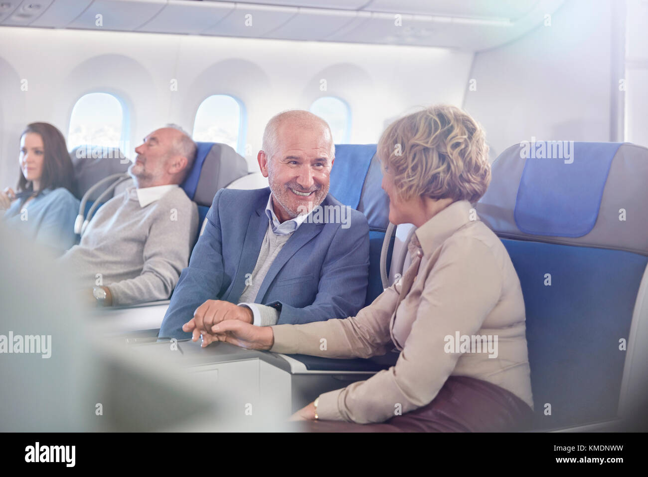 Liebevolles reifes Paar, das Hände auf Flugzeug hält Stockfoto