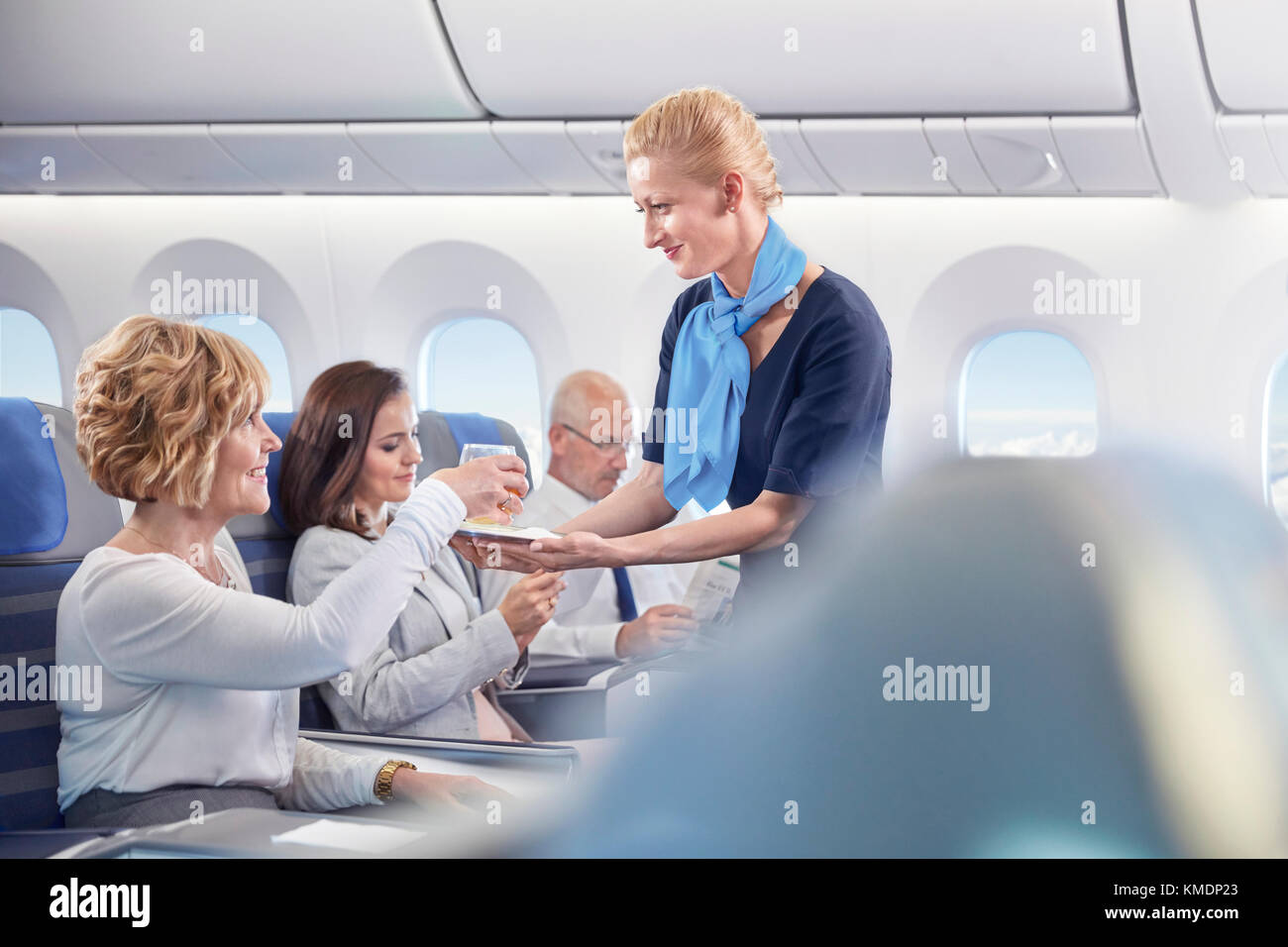 Flugbegleiter serviert der Frau im Flugzeug Getränke Stockfoto