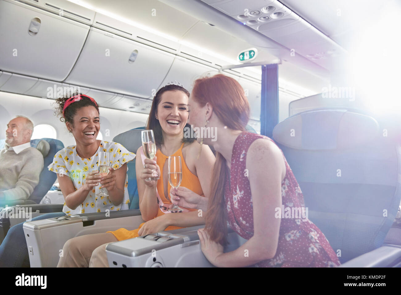 Junge Freundinnen trinken Champagner in der ersten Klasse im Flugzeug Stockfoto