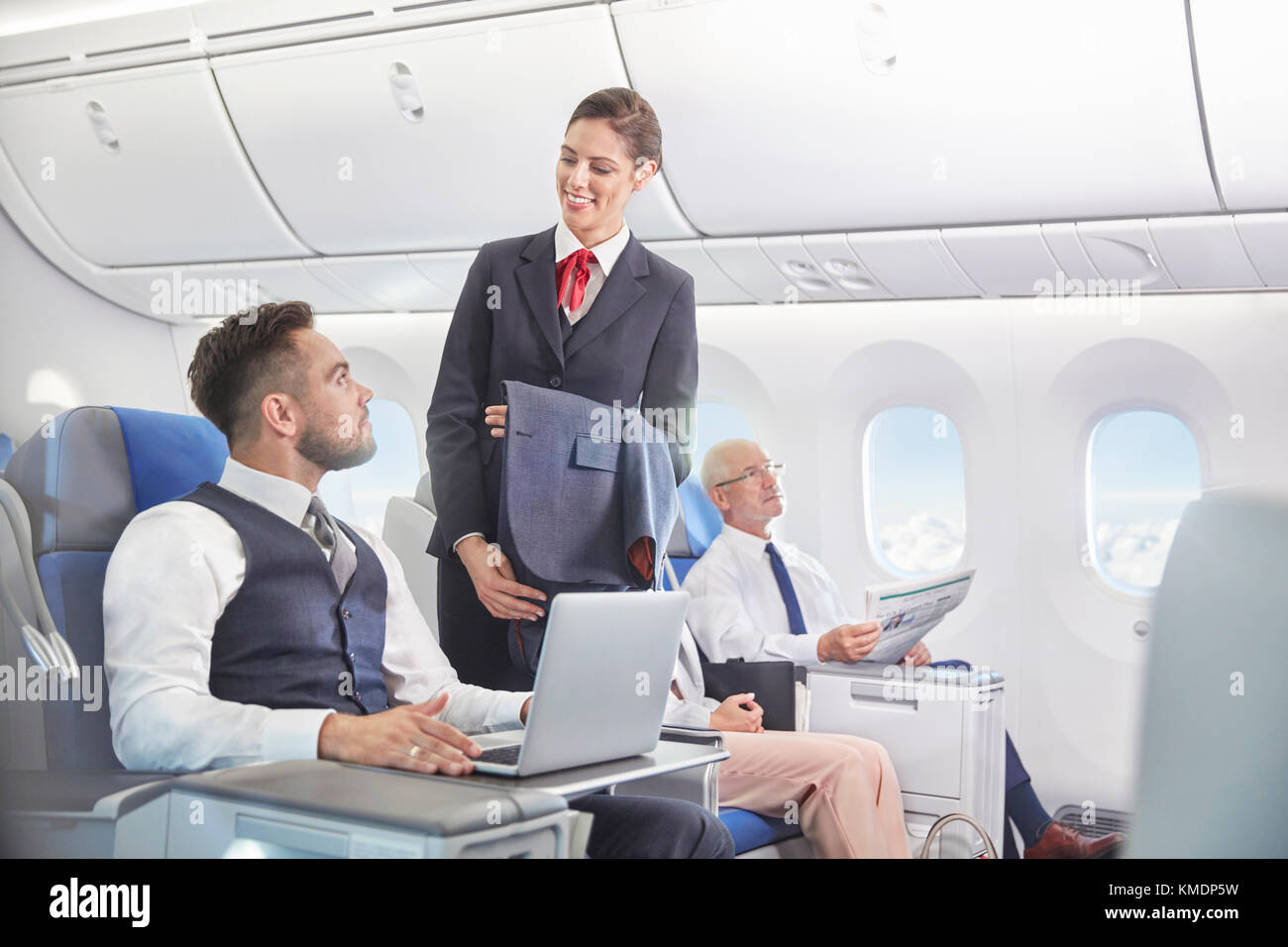 Flight Attendant im Gespräch mit Unternehmer Arbeiten am Laptop auf dem Flugzeug Stockfoto