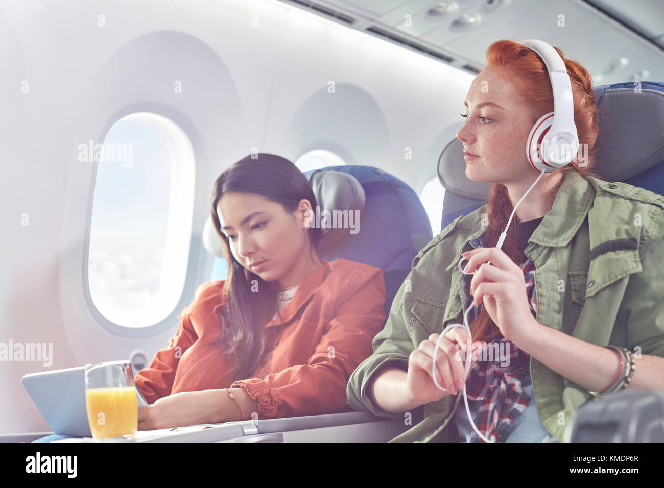 Junge Frauen, die Freunde mit Kopfhörern und digitale Tablet auf Flugmodus Stockfoto