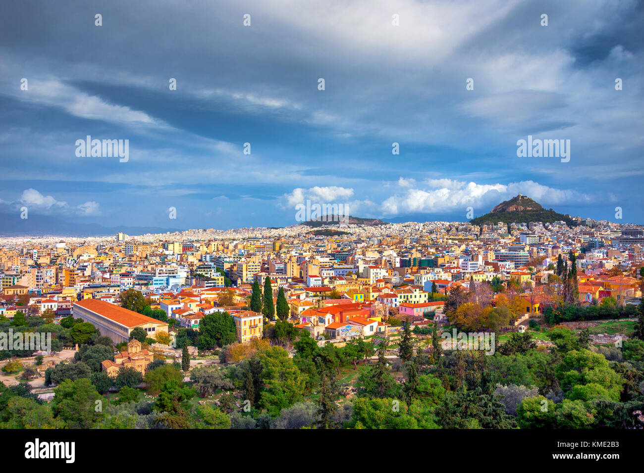 Blick auf den Alten Markt (Agora) mit Ruinen der berühmten klassischen griechischen Zivilisation und die Stadt Athen mit dem Hügel von Lycabetus. Stockfoto