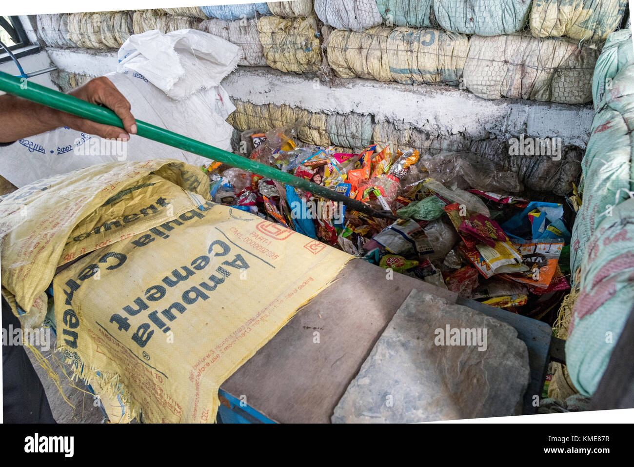 Ein Mann die Vermischung der Kunststoff Wrapper vor der Verarbeitung, Kunststoff, Ziegel, um negativen Auswirkungen von Kunststoffen zu vermeiden, Es trägt zur nachhaltigen Dev Stockfoto