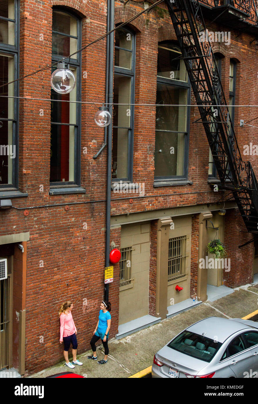 Zwei Läuferinnen machen eine Pause in einer Gasse in Seattle, WA beim abendlichen ausführen. Stockfoto