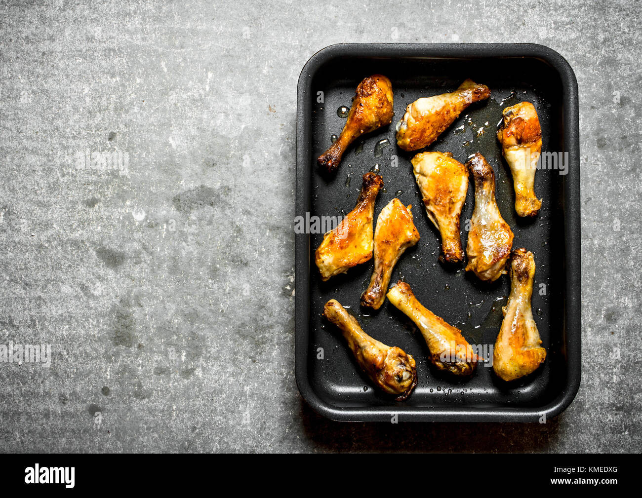 Fried Chicken Beine auf dem Backblech. Auf dem Tisch aus Stein. Stockfoto