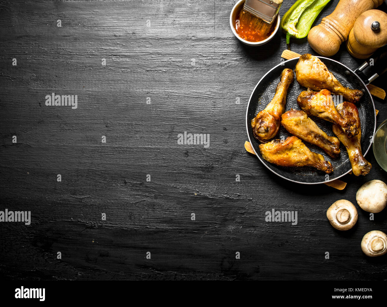 Gebratenes Huhn in einer Pfanne mit Pilzen, Knoblauch und Tomatensauce. Stockfoto