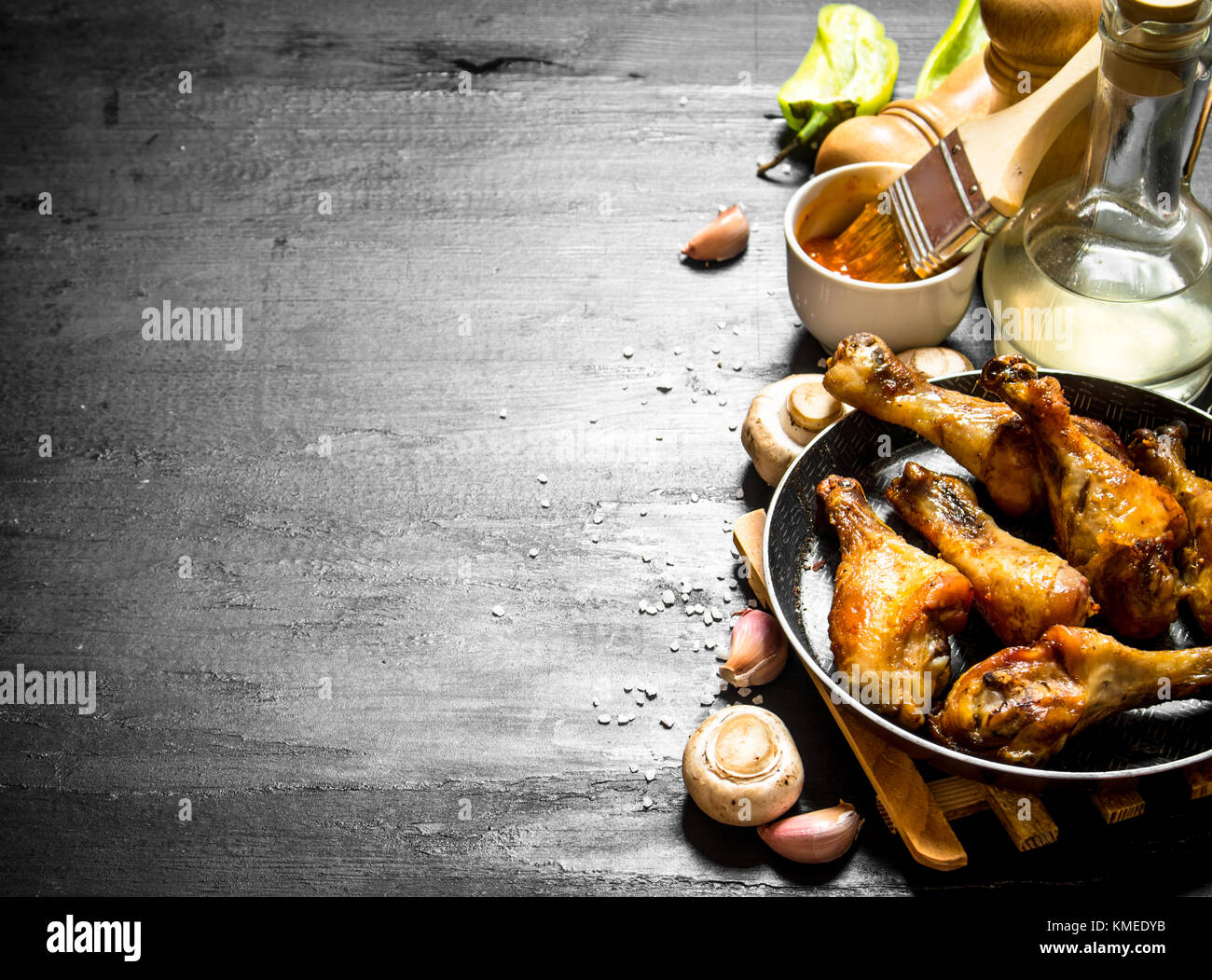 Gebratenes Huhn in einer Pfanne mit Pilzen, Knoblauch und Tomatensauce. Stockfoto