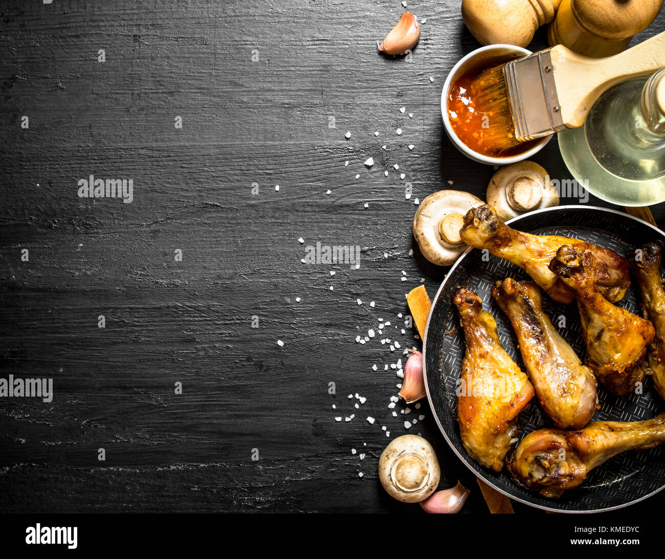 Gebratenes Huhn in einer Pfanne mit Pilzen, Knoblauch und Tomatensauce. Stockfoto