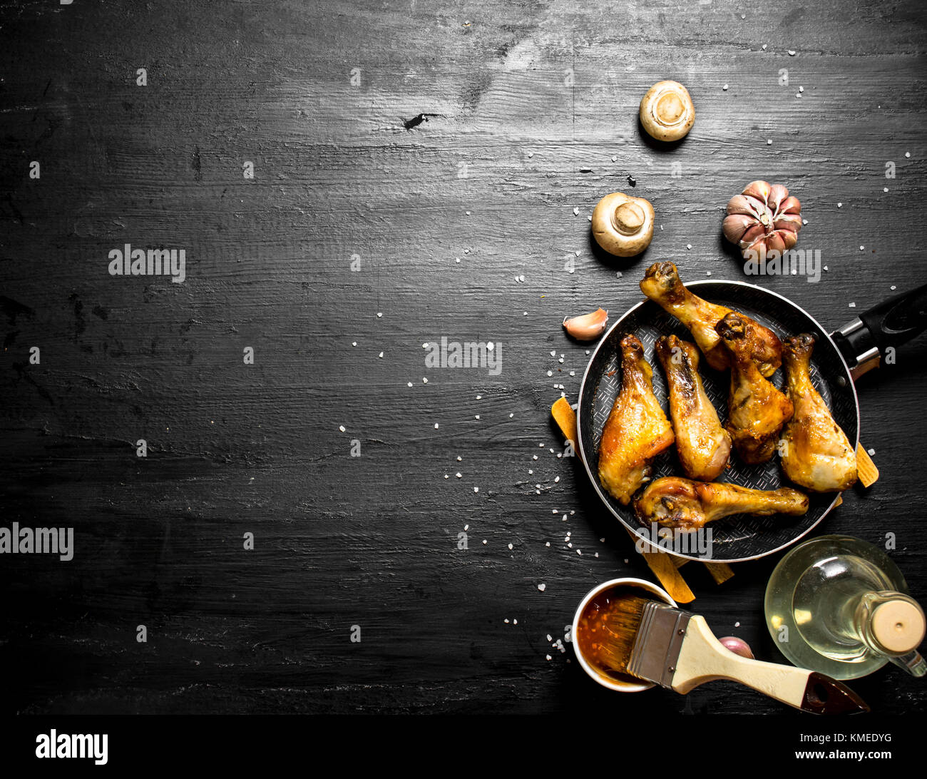 Gebratenes Huhn in einer Pfanne mit Pilzen, Knoblauch und Tomatensauce. Stockfoto