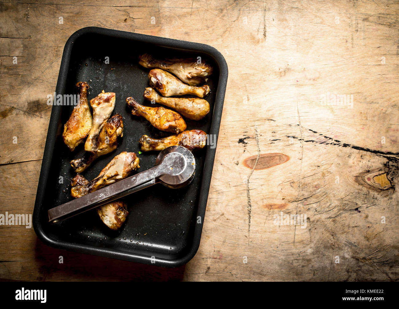 Hähnchenschenkel auf dem Backblech. Auf einem Holztisch. Stockfoto