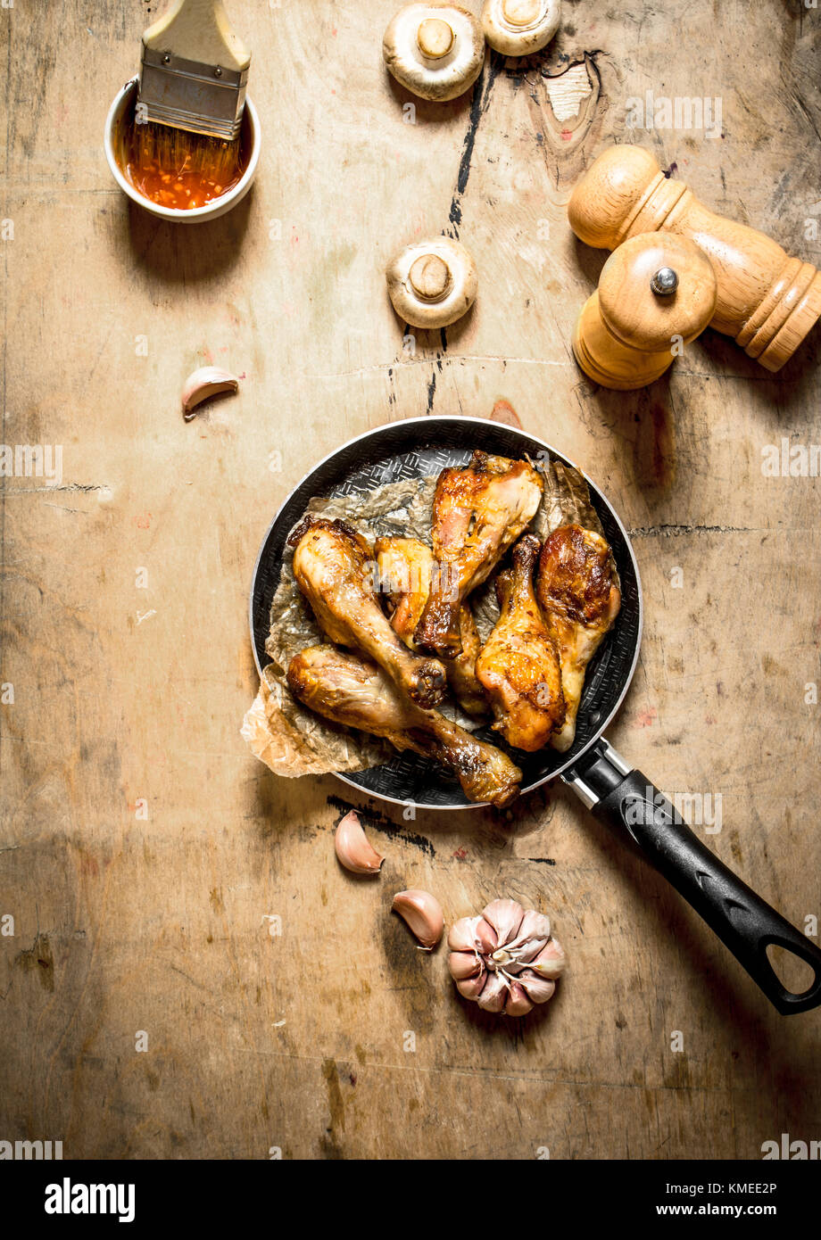 Fried Chicken Beine in einer Pfanne mit Tomaten, Pilze und Knoblauch. Stockfoto