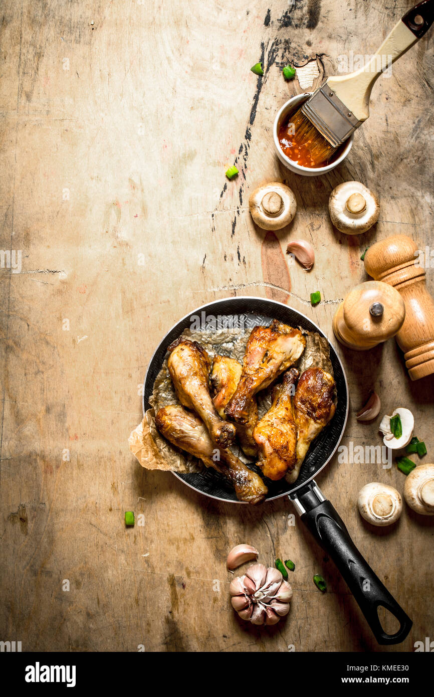 Fried Chicken Beine in einer Pfanne mit Tomaten, Pilze und Knoblauch. Stockfoto