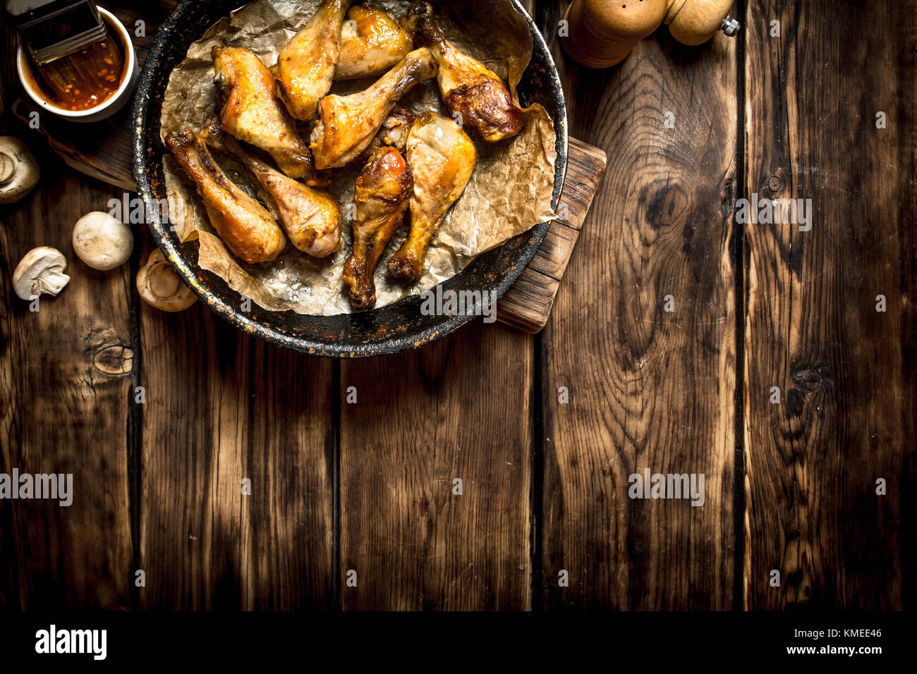 Gebratene Hähnchenschenkel mit Tomatensoße. Auf einem Holztisch. Stockfoto
