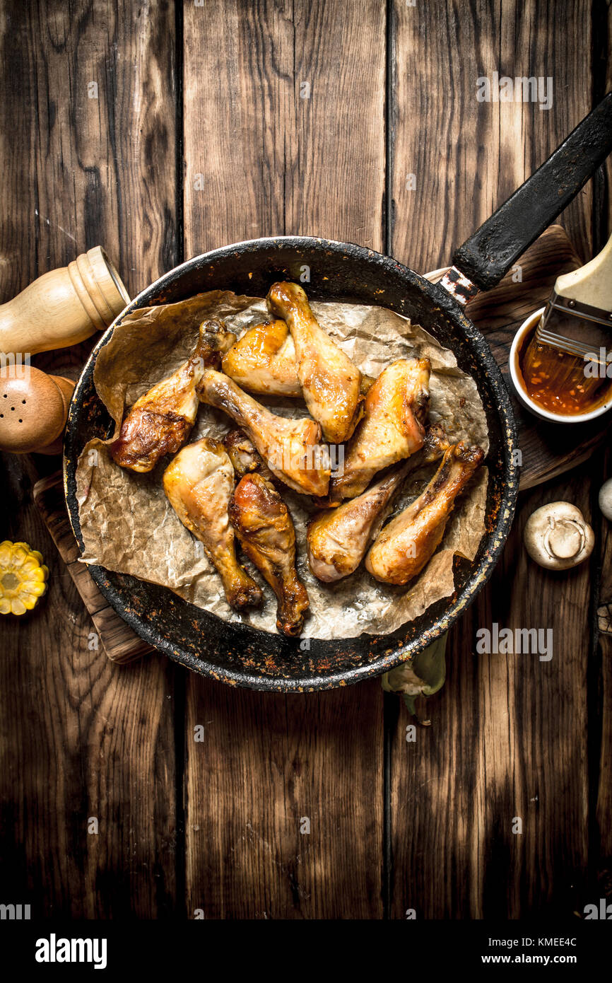 Gebratene Hähnchenschenkel mit Tomatensoße. Auf einem Holztisch. Stockfoto