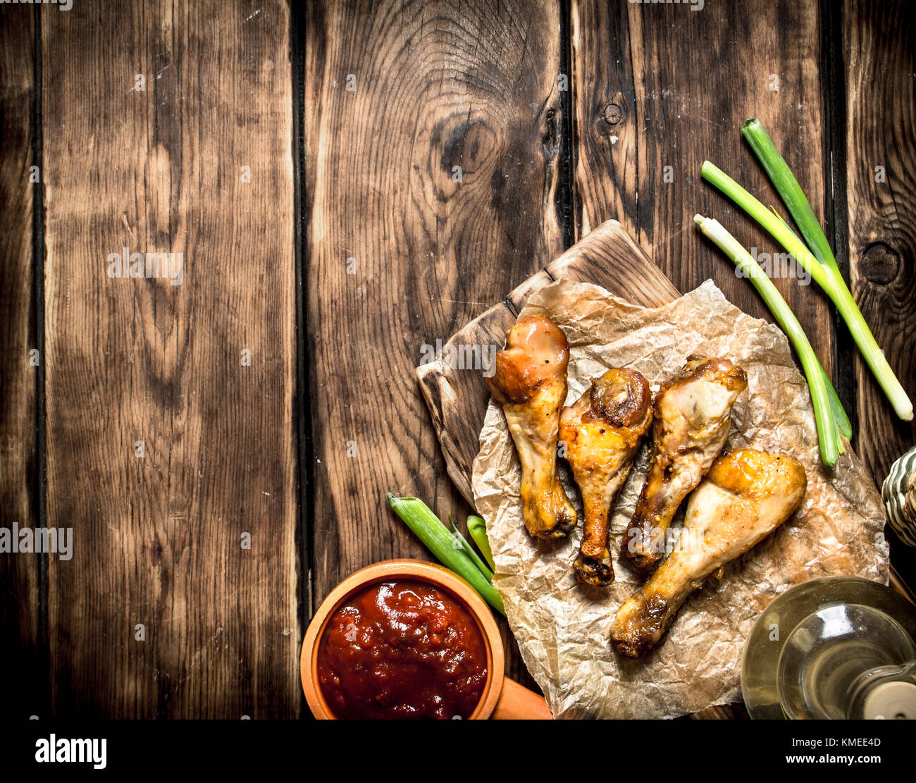 Gebratene Hähnchenschenkel mit Tomatensoße. Auf einem Holztisch. Stockfoto