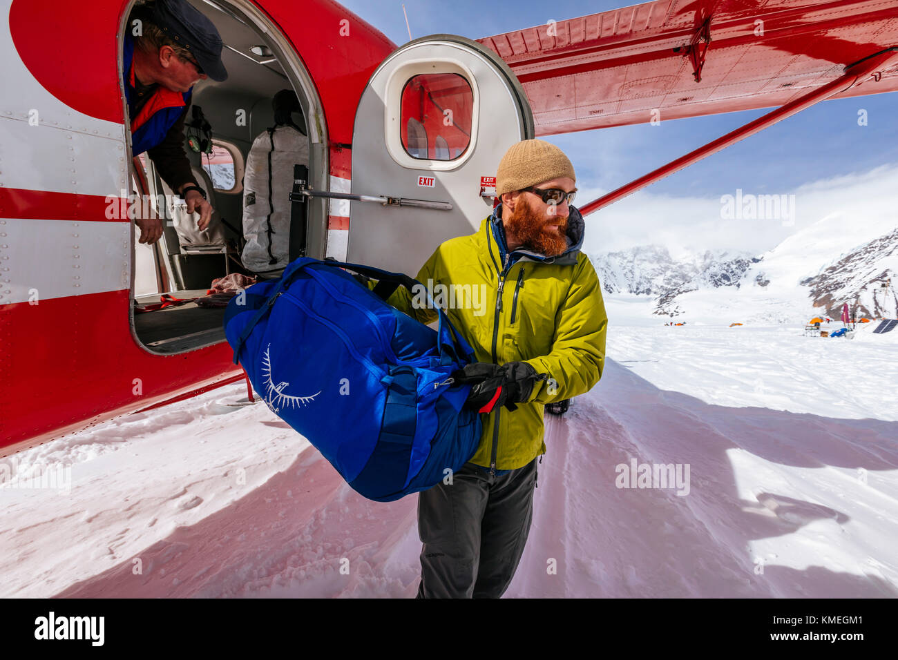 Bergsteiger entladen Tasche aus dem Flugzeug, Denali National Park, Alaska, USA Stockfoto