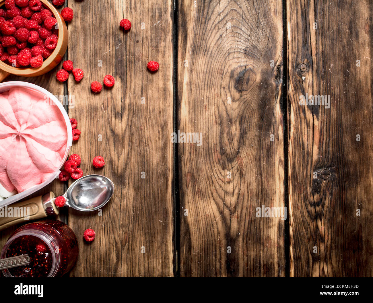 Himbeermarmelade mit Eis und Waldbeeren. Auf einem Holztisch. Stockfoto