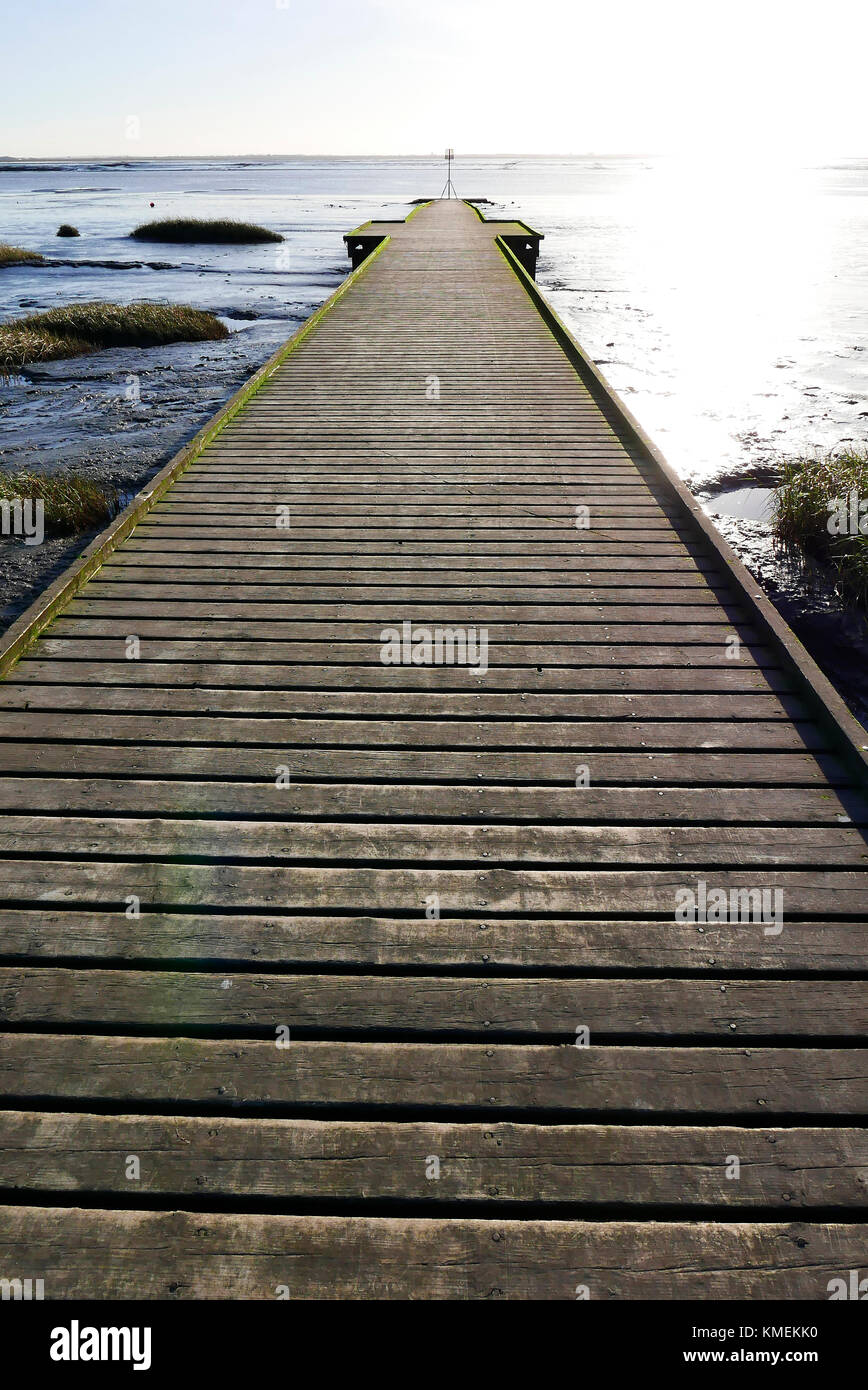 Ende der Steg in die Mündung des Flusses gegen tiefstehende Sonne im Winter Stockfoto