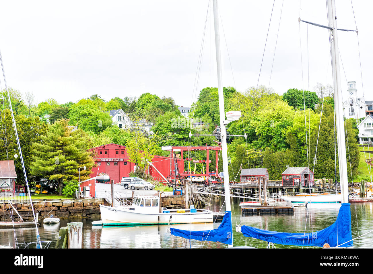 Rockport, USA - Juni 9, 2017: leere Marina Hafen in einem kleinen Dorf in Maine bei Regen mit Booten und Blick auf die Innenstadt, Zeichen auf Gebäude Stockfoto