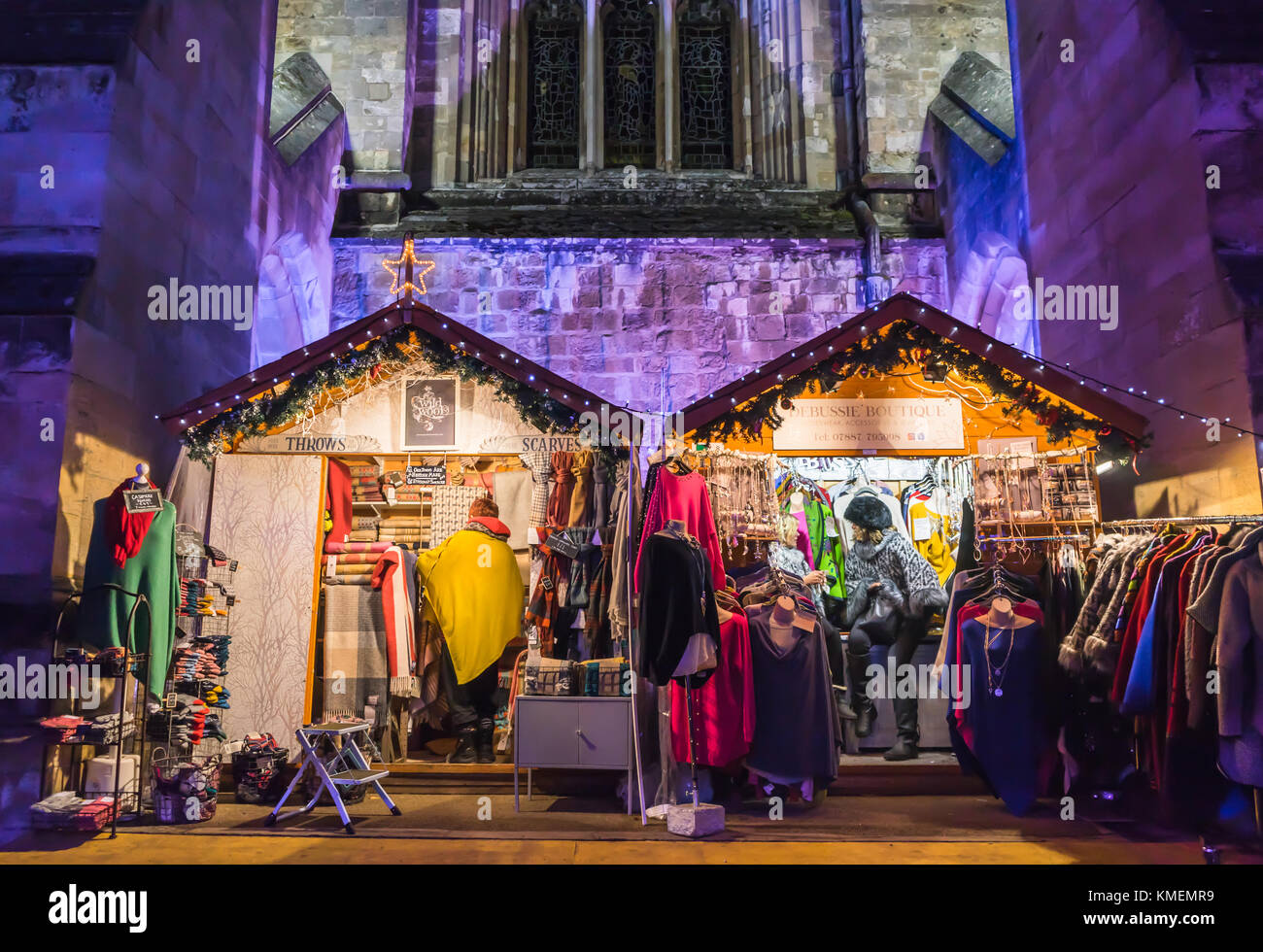 Lebendige Bunte Marktstände mit der beleuchteten Kathedrale von Winchester, die im Hintergrund an der Winchester Weihnachtsmarkt 2017, Winchester, England, Großbritannien Stockfoto