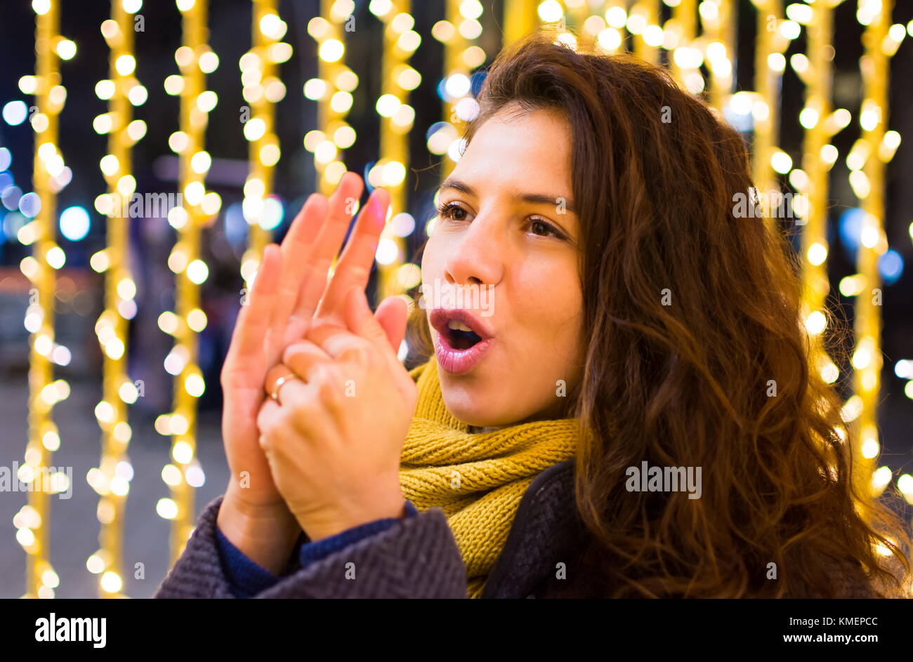 Mädchen Aufwärmen ihre Hände im Winter mit festlichen Hintergrund Stockfoto